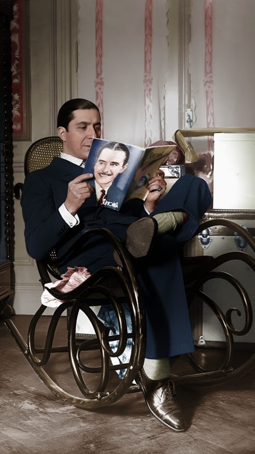 Carlos Gardel — Carlos Gardel en su casa, sentado en una mecedora, leyendo un ejemplar de la revista "Sintonía".