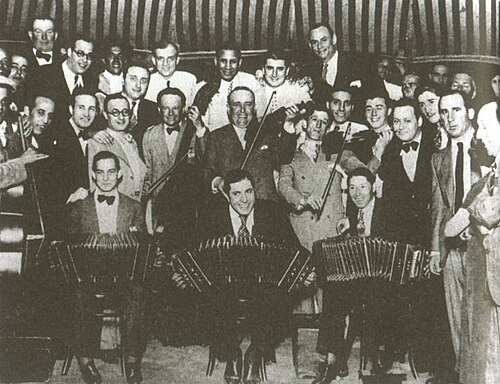 Carlos Gardel — Fiesta de despedida a Carlos Gardel el 5 de noviembre de 1933, antes de su gira mundial. Gardel al centro con bandoneón, junto a los jockeys Leguisamo y Peluffo.